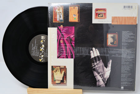Vinyl record with a colorful cover featuring a hand and text on a white background