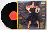Vinyl record with a colorful cover featuring a woman in a black dress.