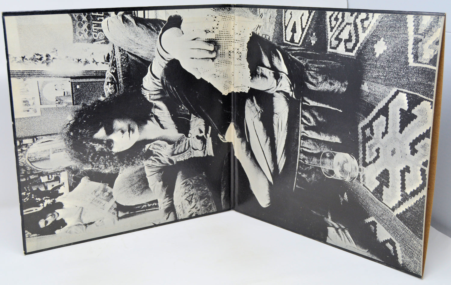 Open book with black and white photographs of people in a room.