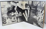 Open book with black and white photographs of people in a room.