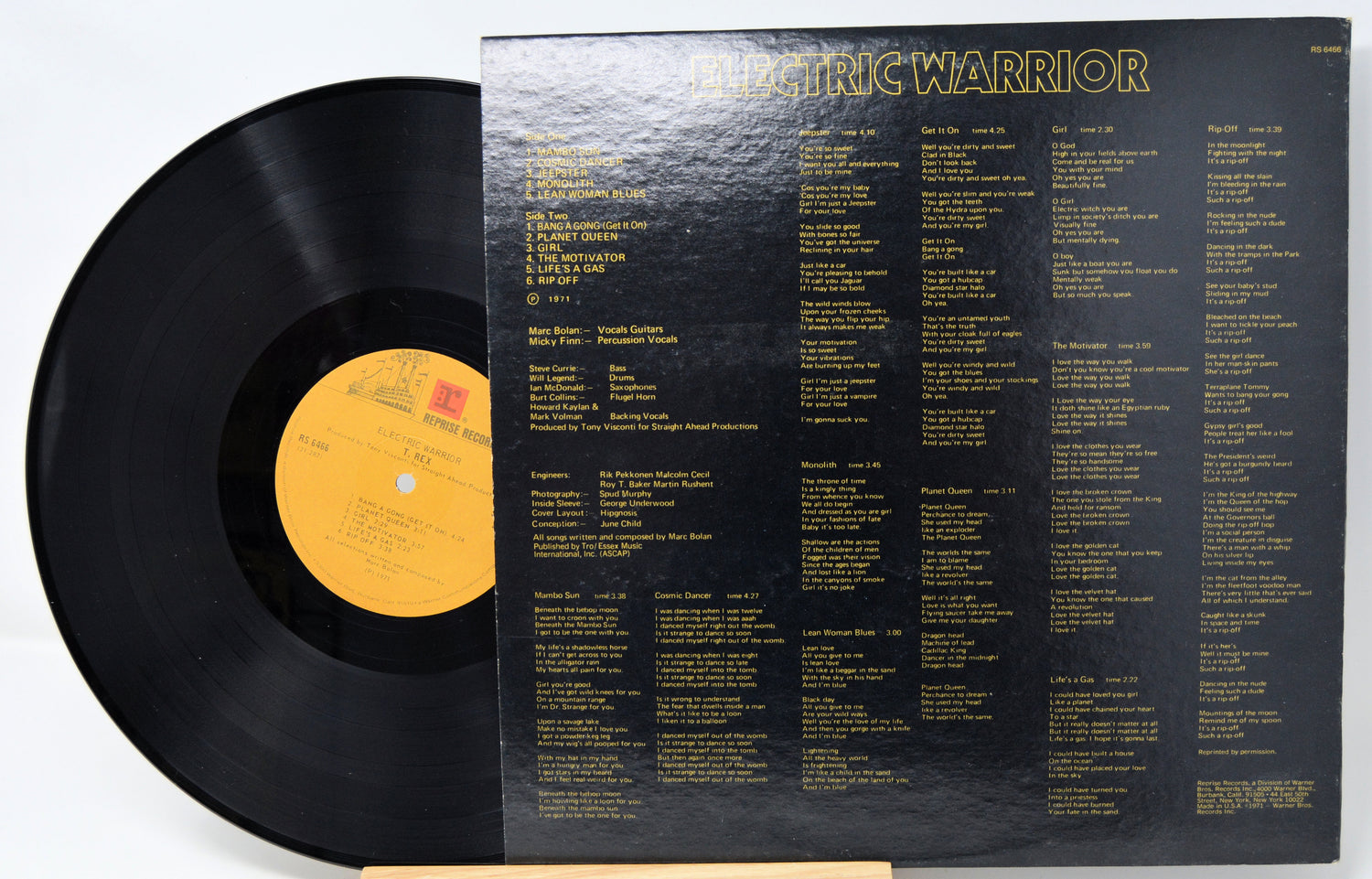 Vinyl record with yellow label and black cover displaying tracklist on a white background