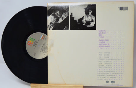 Vinyl record with cover featuring black and white photos and text on a light gray background