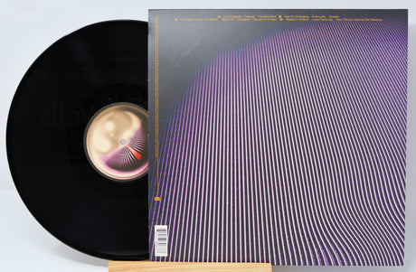 A vinyl record of the album 'Currents' by Tame Impala, featuring a purple rear album cover with a stylized design.