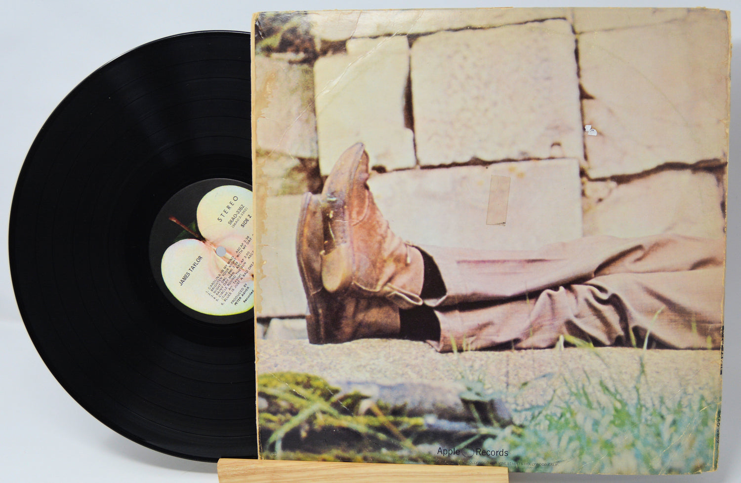 Vinyl record 'James Taylor - Self Titled' with a back cover showing a person in boots and a patterned dress on a stone wall.