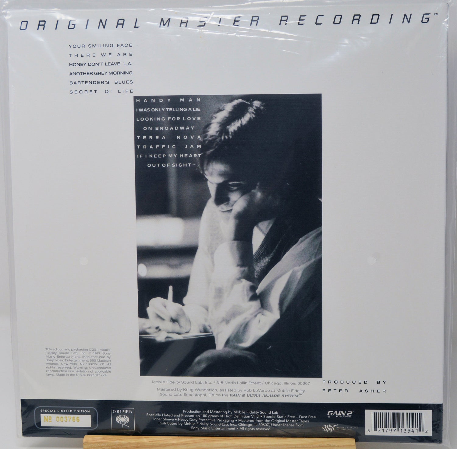 Vinyl record sleeve for Miles Davis' 'Original Master Recording' LP, sealed in plastic shrink wrap. The white cover features a large black-and-white portrait of Davis, tracklist text on the left, and a black label band at the bottom with a barcode.