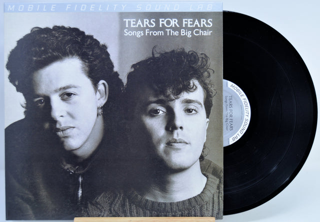 Tears For Fears - 'Songs From The Big Chair' vinyl record with the album cover on the left and the black LP record partially visible on the right against a light background.