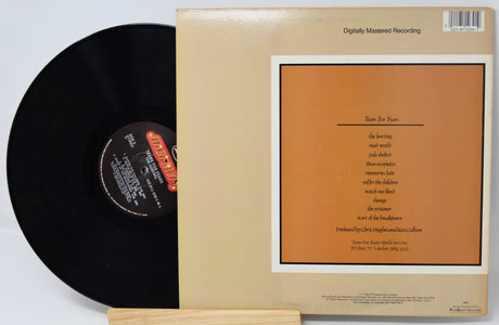 Vinyl record with its cover displaying text and a barcode on a light gray background