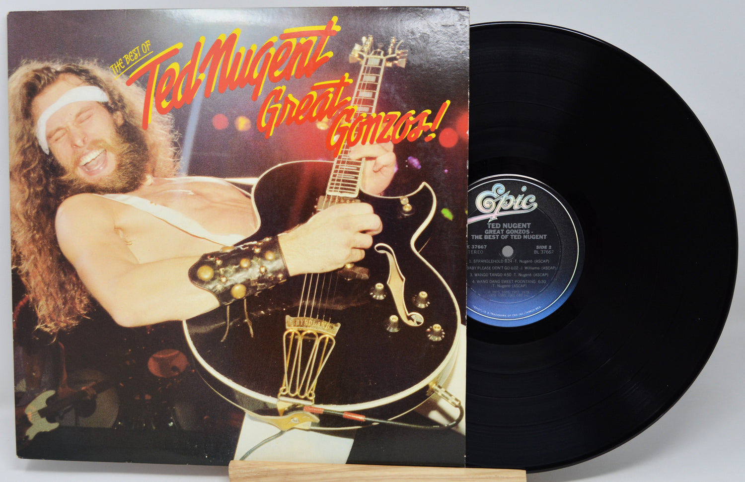 A vinyl record album for Ted Nugent's 'Grant Gonzales!' shown with its illustrated cover sleeve and a black LP disc on a stand against a light gray background.
