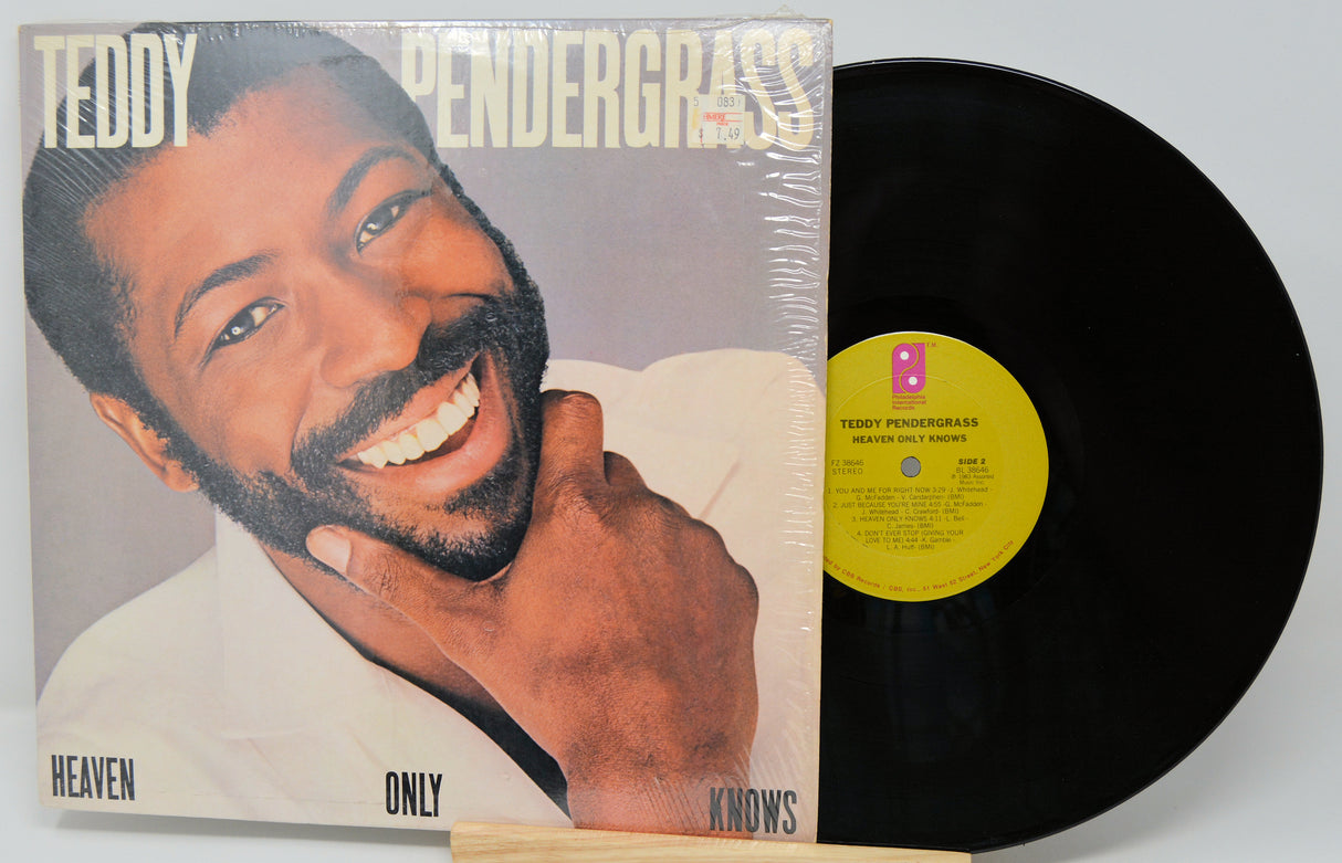 Vinyl record with cover featuring a smiling man, labeled 'Heaven Only Knows' by Teddy Pendergrass.