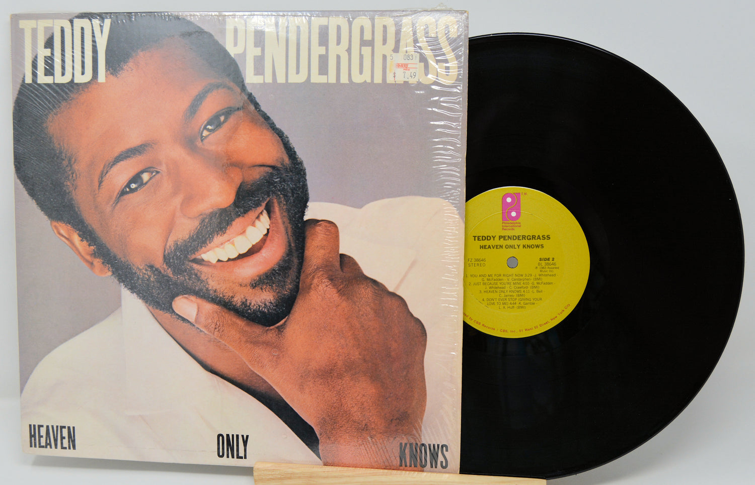 Vinyl record with cover featuring a smiling man, labeled 'Heaven Only Knows' by Teddy Pendergrass.