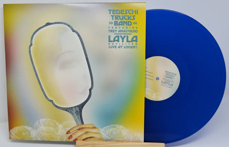 Layla's 'Live at Lockn' 12-inch vinyl record with its illustrated album cover sleeve, featuring a blue record partially pulled from the sleeve on a small wooden stand.