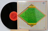 Vinyl record with cover displaying song titles on a light gray background