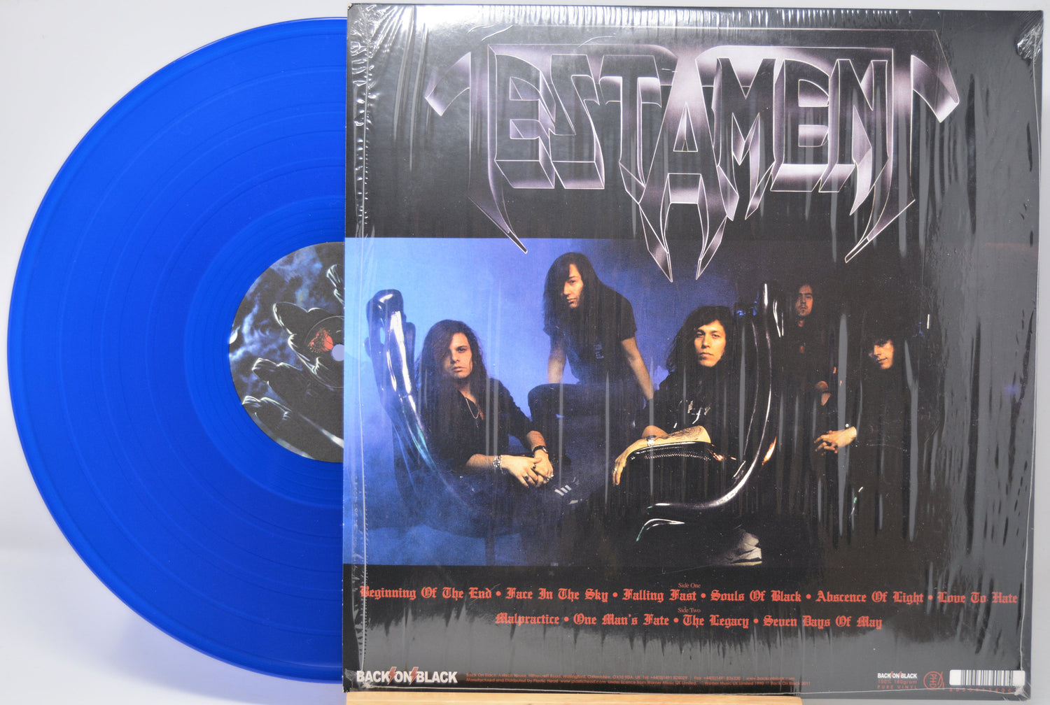 Blue vinyl record with 'Testament' album cover featuring a band on a white background