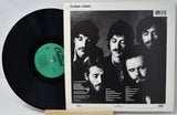 Vinyl record with a black cover featuring a band's faces and a white label.