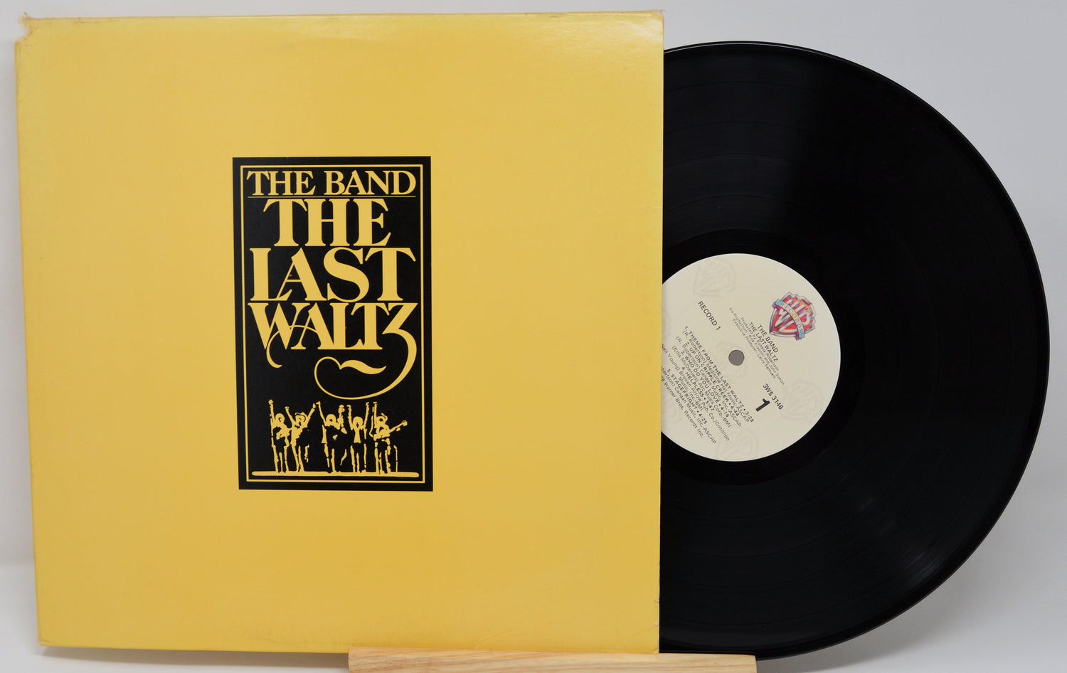 Vinyl record and cover of 'The Last Waltz' by The Band on a gray background