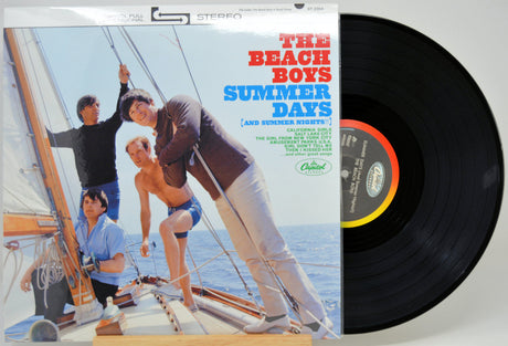 The Beach Boys 'Summer Days' vinyl record album with the printed cover visible on the left and the black LP record partially pulled out on the right, photographed against a light neutral background.