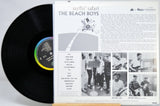 Vinyl record album shown with the black LP partially pulled from the printed inner sleeve. The sleeve features the title 'surfin' safari', the band name 'THE BEACH BOYS', track list, and black-and-white photos of the band members.