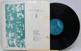Beatles 'Live Concert at Wacken' vinyl record LP with the outer sleeve on the left and the black record partially visible on the right. The sleeve features a teal-toned collage of band members on the left and printed track listing text on the right, all wrapped in clear plastic.