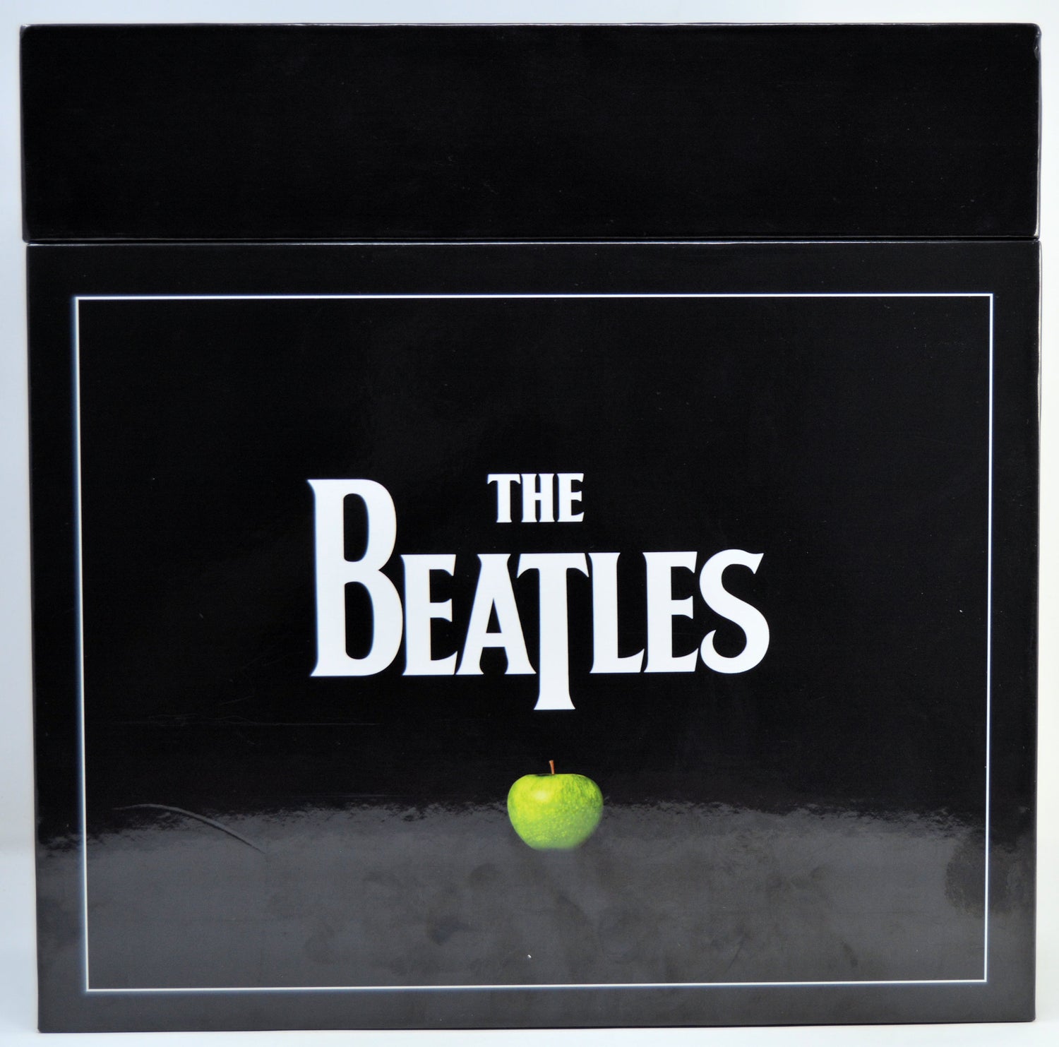 The Beatles album box set featuring the iconic black cover with the band's name in white and a single green apple at the bottom.
