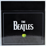 The Beatles album box set featuring the iconic black cover with the band's name in white and a single green apple at the bottom.