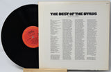 Vinyl record with a white label featuring text and a red label on a light gray background