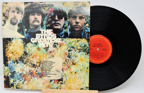 Vinyl record with colorful cover featuring band members and floral design