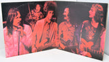 Vintage album cover with band members and pink-red color scheme.