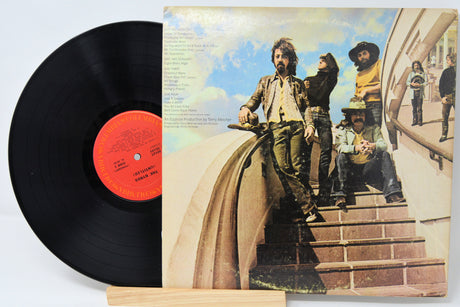 Vinyl record with colorful cover art featuring people on steps.