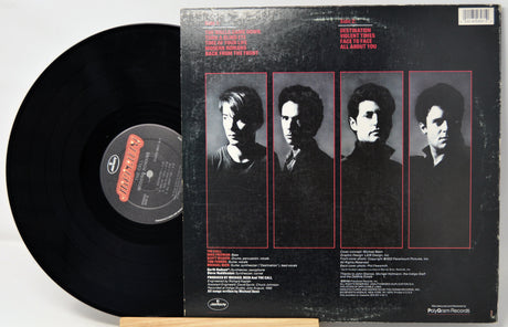 Vinyl record with a black cover featuring four portraits and a label.