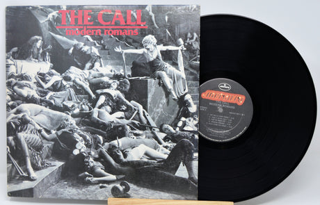 Vinyl record with cover featuring a black and white illustration of people on a stone platform.