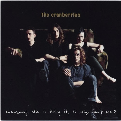 The image shows the cover of The Cranberries' debut album 'Everybody Else Is Doing It'. It features a photo of the band members sitting close together with a dark background.