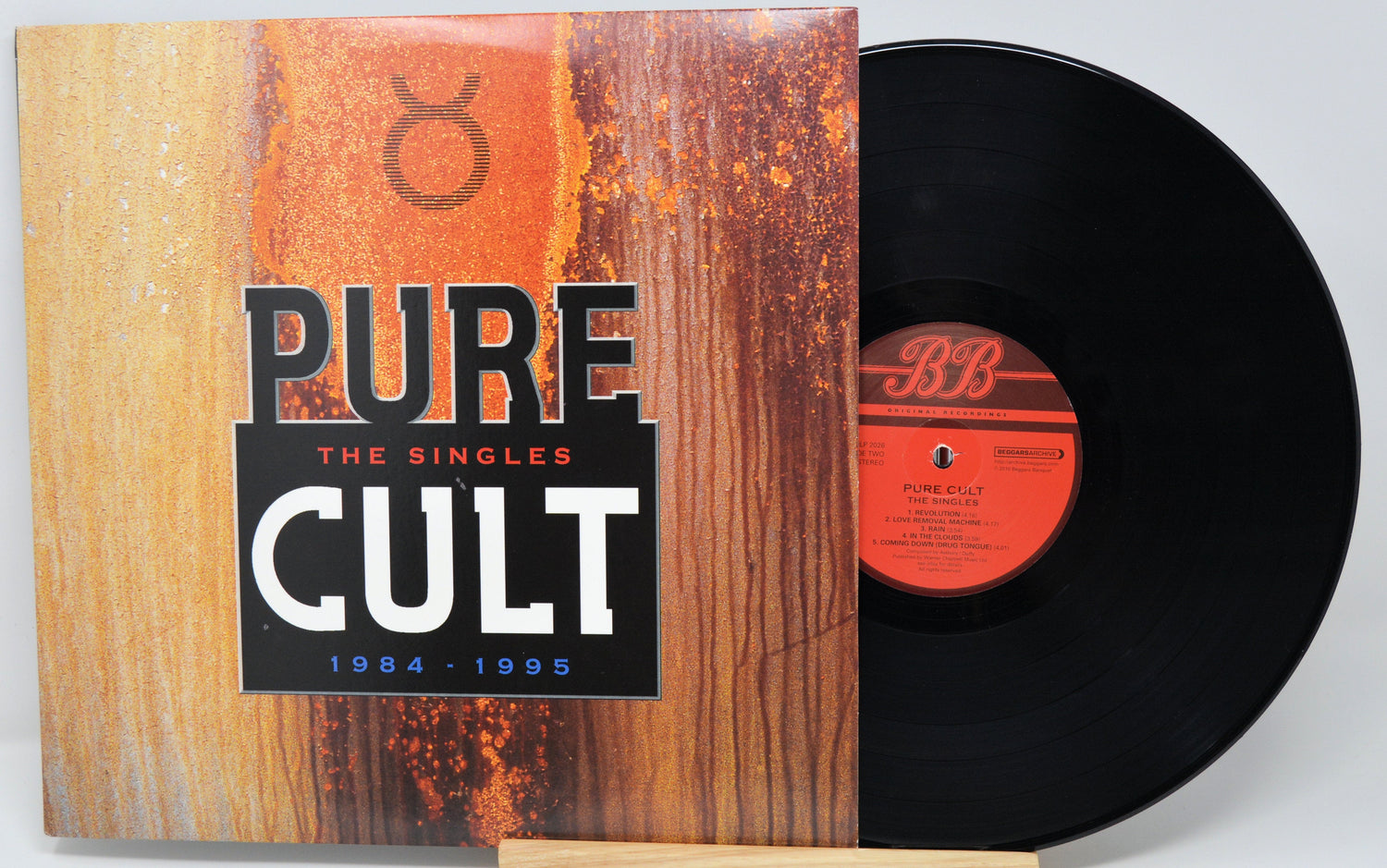 Front cover of The Cult's Pure Cult: The Singles 1984-1995 vinyl record with bold logo and rust design