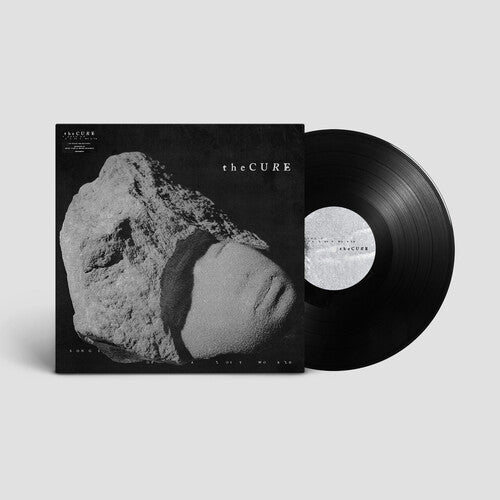 A black vinyl record of The Cure's album 'Songs Of A Lost World' with a sculpture-like object on the cover, predominantly in gray and black tones.