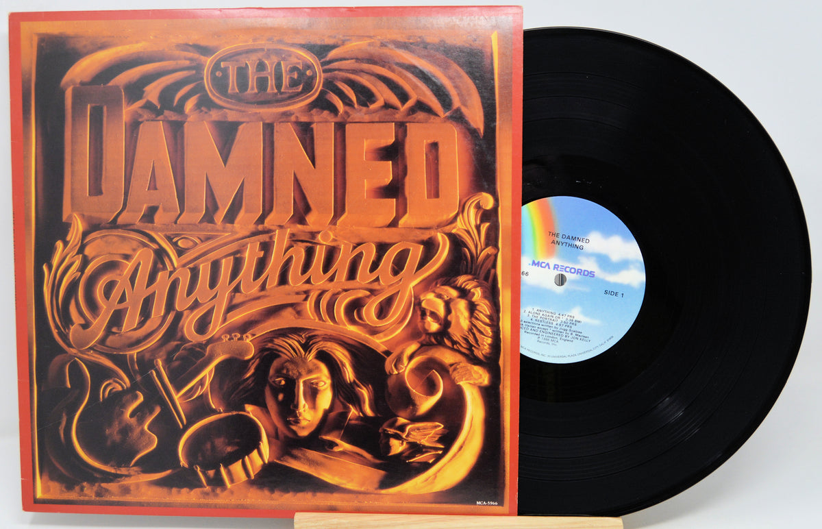 Damned Anything vinyl record album with the illustrated cover standing beside the black LP disc on a light background.