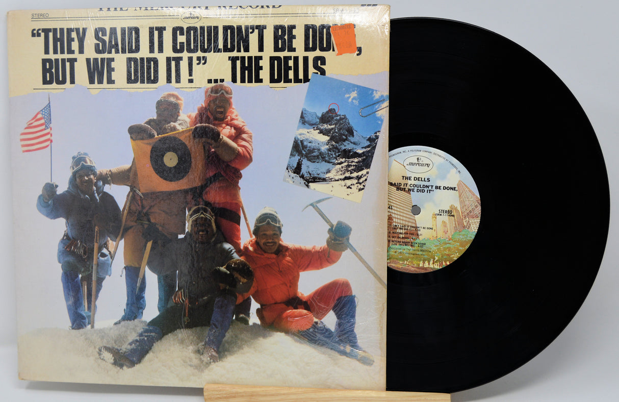 Vinyl record with cover featuring mountain climbers and text 'They said it couldn't be done, but we did it! The Delis'.