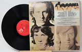 Vinyl record with a cover featuring three faces and text on a white background