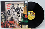 Vinyl record with cover featuring a band photo and a bottle of Moet champagne.