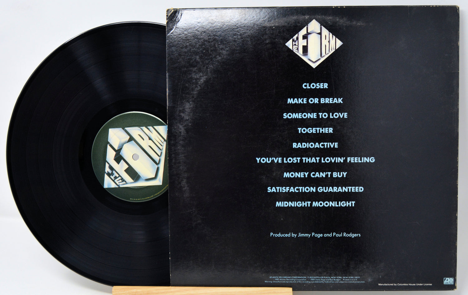 Vinyl record with cover displaying tracklist on a white background