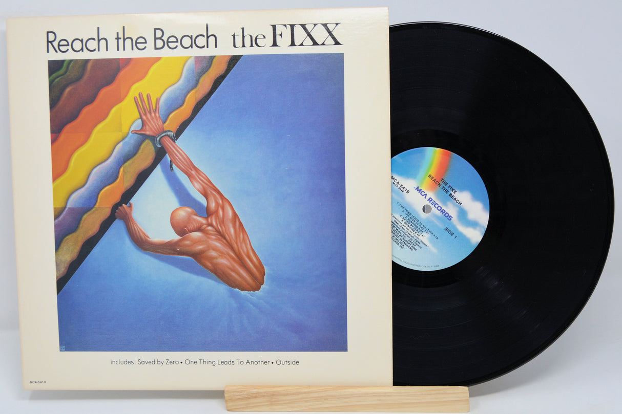 Vinyl record and cover of 'Reach the Beach' by The FIXX on a white background