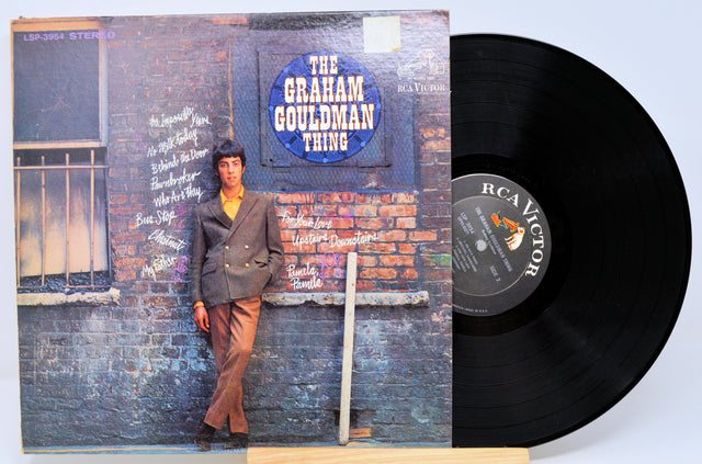 Front cover and vinyl record of The Graham Gouldman Thing featuring Graham Gouldman leaning against a brick wall