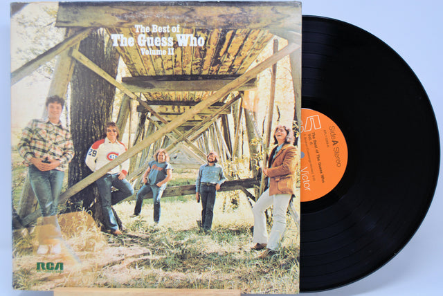 Vinyl record with 'The Best of The Guess Who Volume II' cover showing a group of people by a wooden bridge.