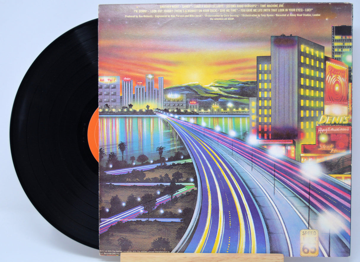 'The Hollies Another Night' Vinyl record with a colorful album cover featuring a cityscape and highway.