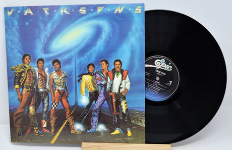 A vinyl record titled 'Jacksons - Victory' with the band The Jacksons on the album cover, displayed next to a turntable.