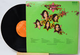Vinyl record with a green cover featuring star designs and faces, on a white background.