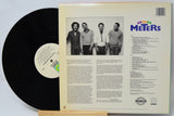 Vinyl record with cover featuring a band photo and text on a light gray background