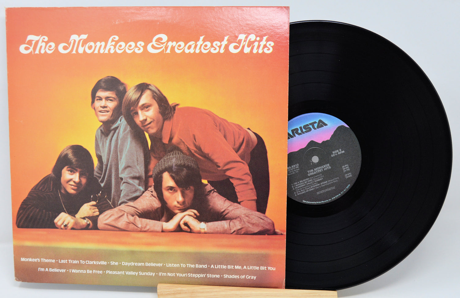 Vinyl record with 'The Monkees Greatest Hits' album cover showing four band members.