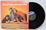 Vinyl record with 'The Monkees Greatest Hits' album cover showing four band members.
