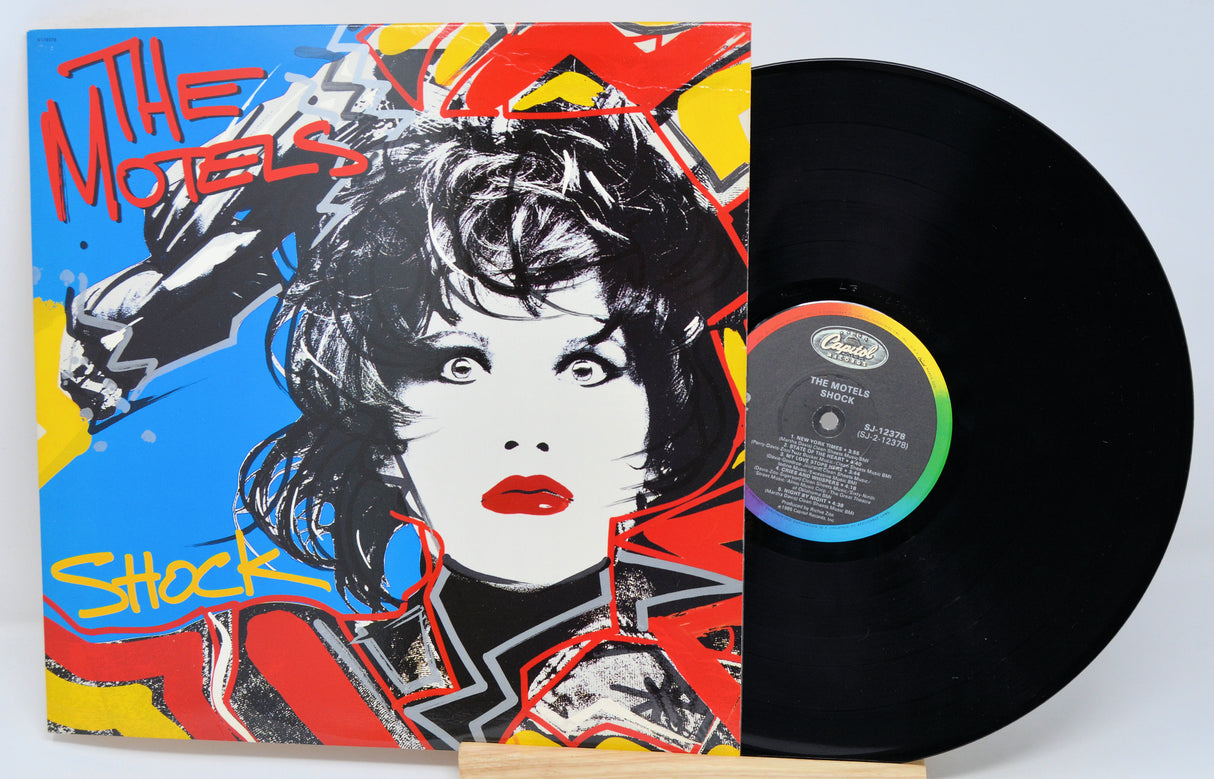 Vinyl record with colorful cover featuring a stylized portrait and text.