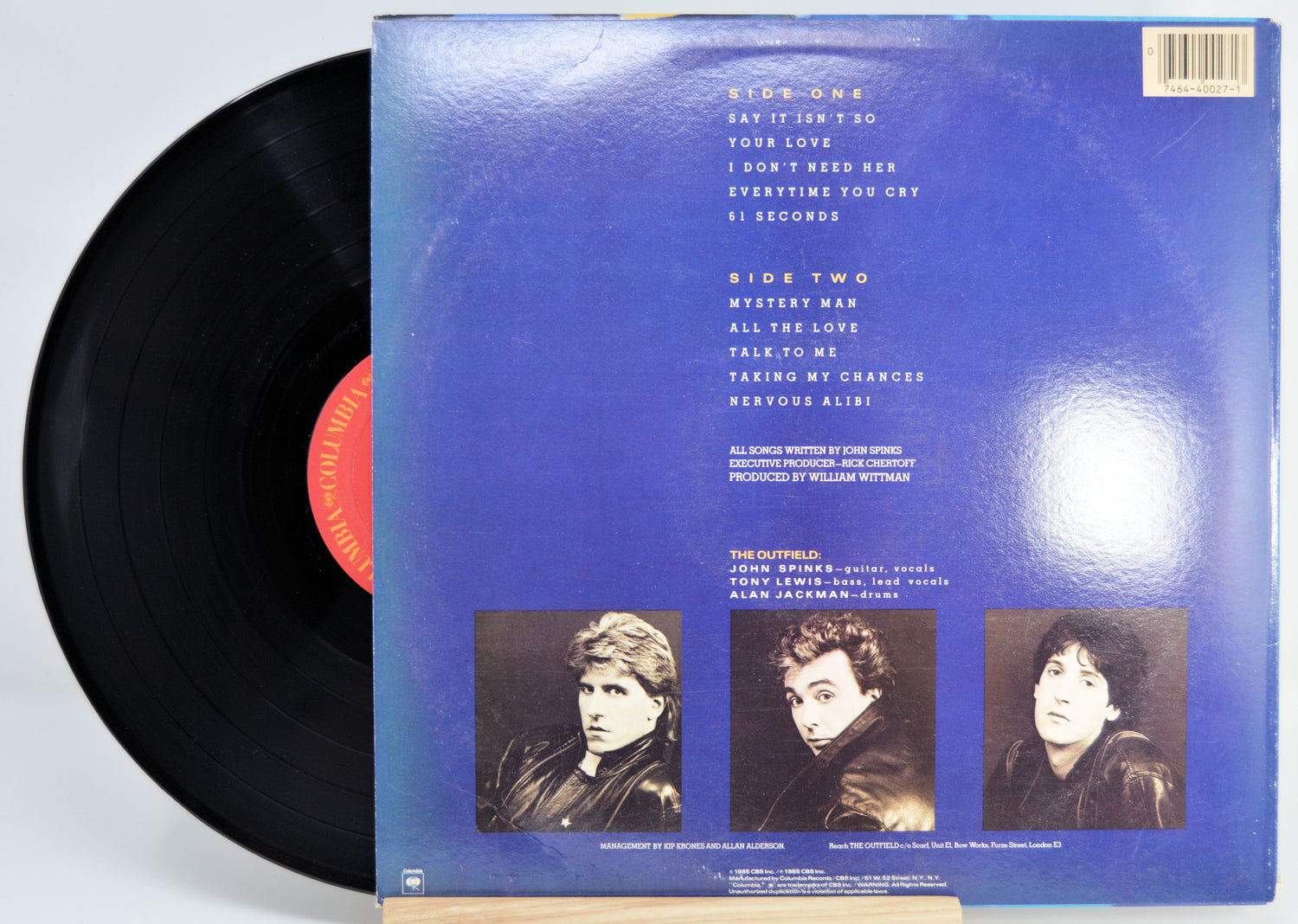 Vinyl record with blue cover featuring text and individual images of the three band members.