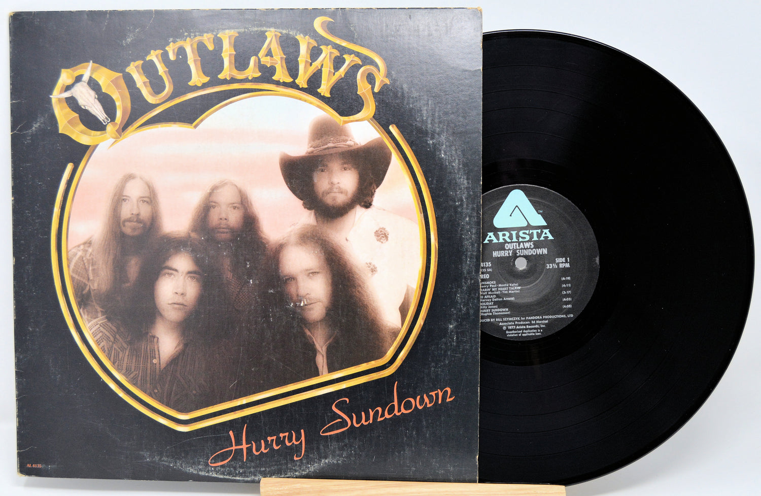 Vinyl record with 'Outlaws' album cover featuring a band portrait.
